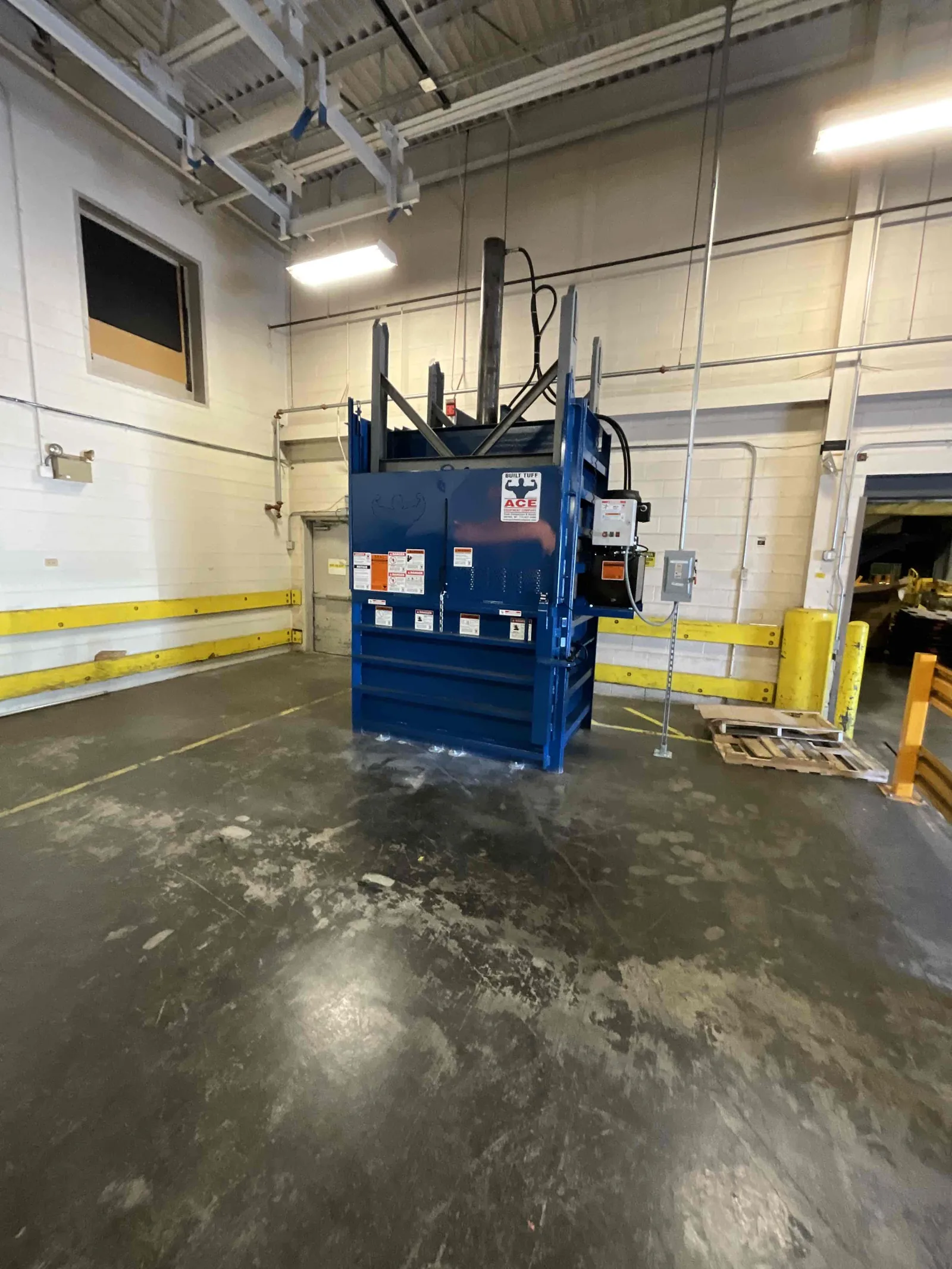 A blue vertical baler newly installed