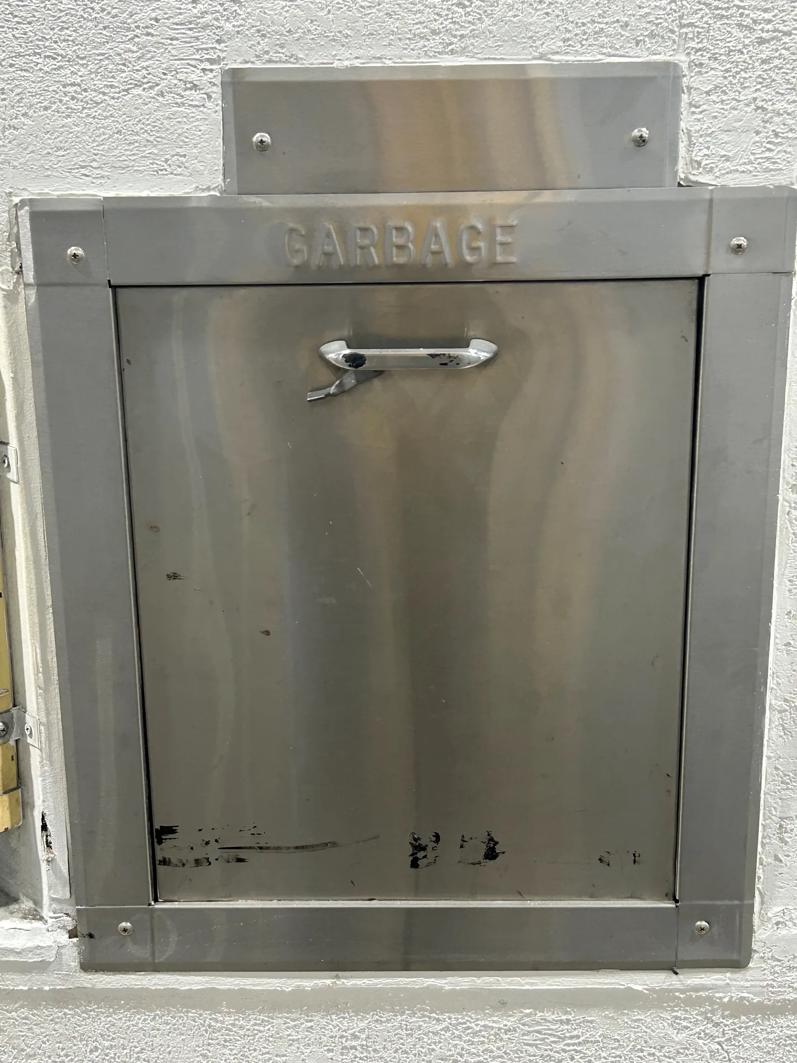 A garbage chute door in a high rise
