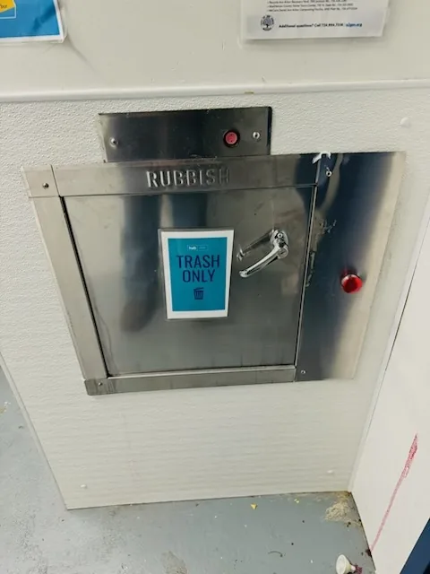 A trash chute intake door with a keypad
