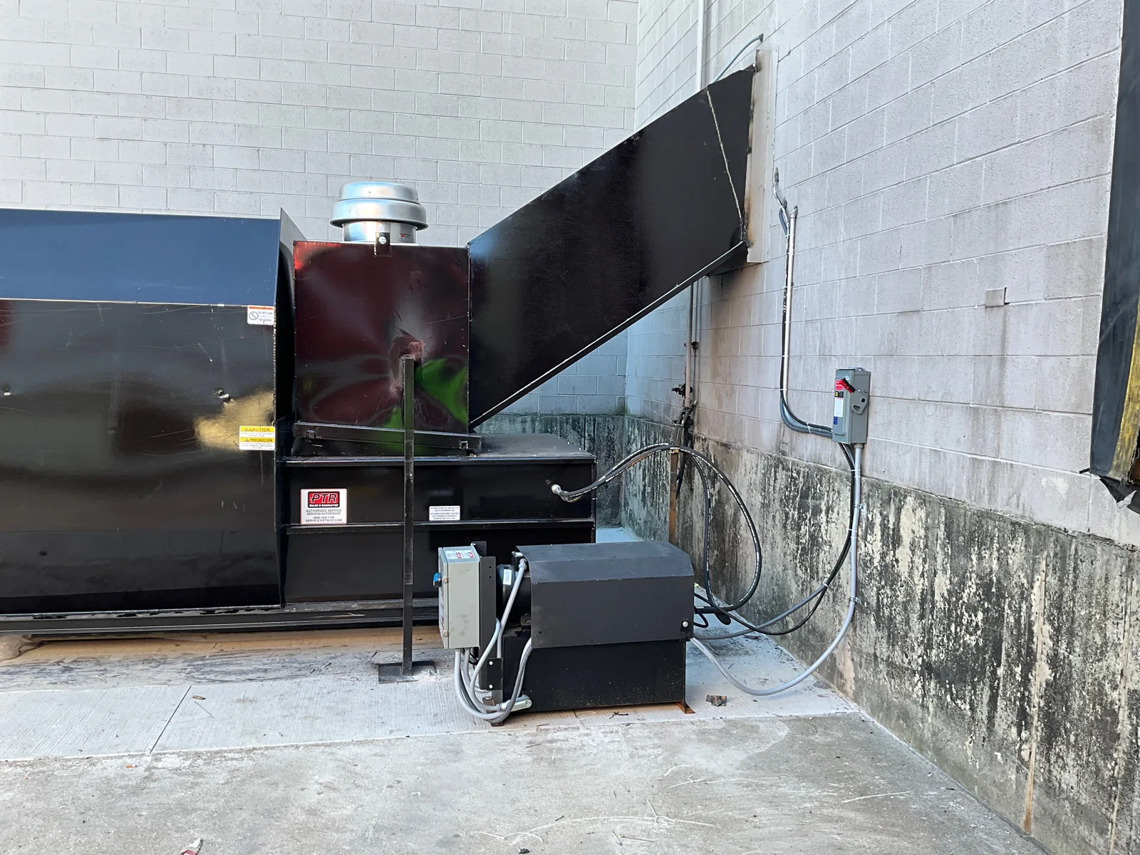 A compactor connected to a building trash chute