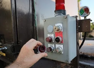 A technician operating a compactor control panel
