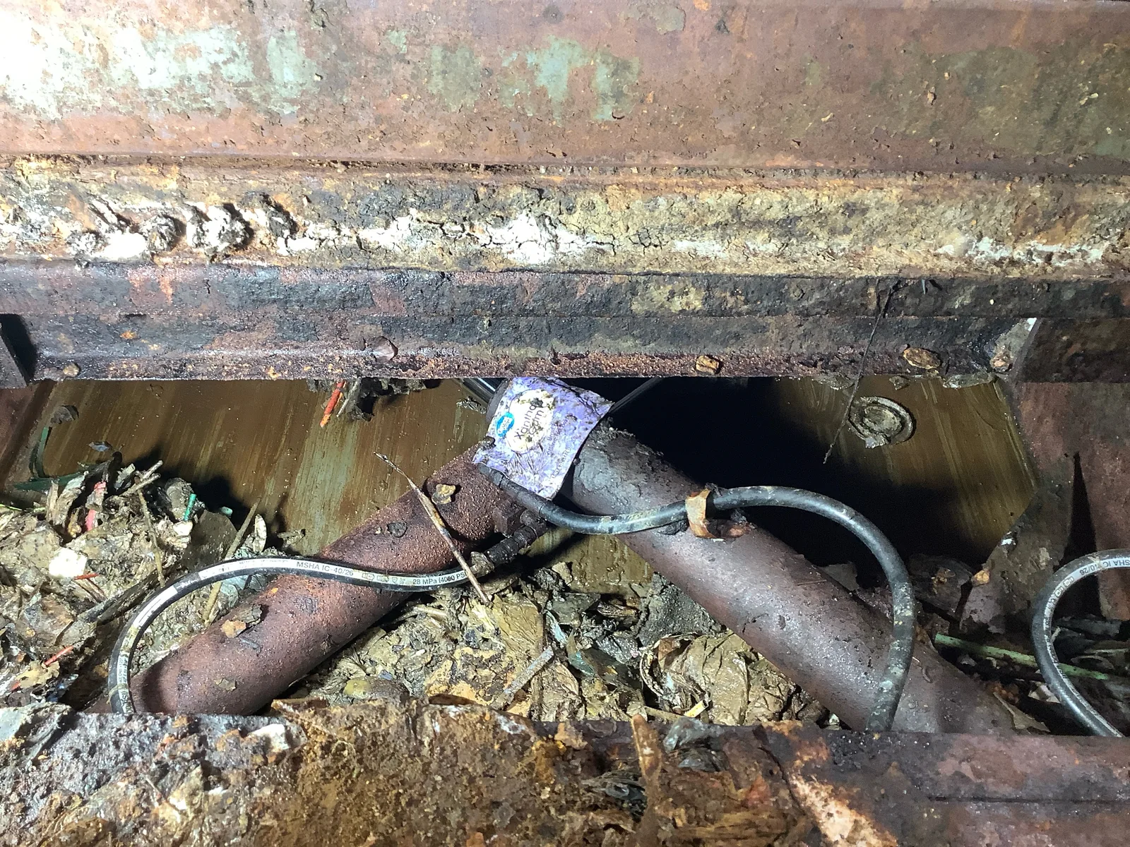 A worn compactor component in need of repair
