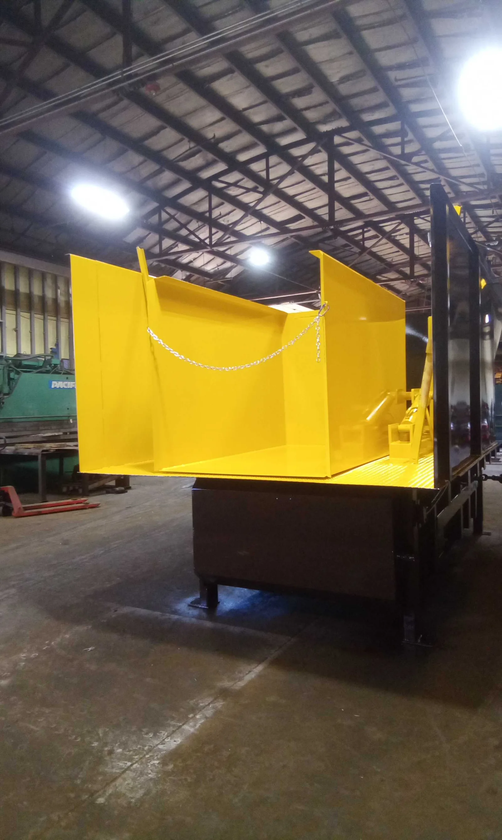 A yellow chute hopper in a loading dock