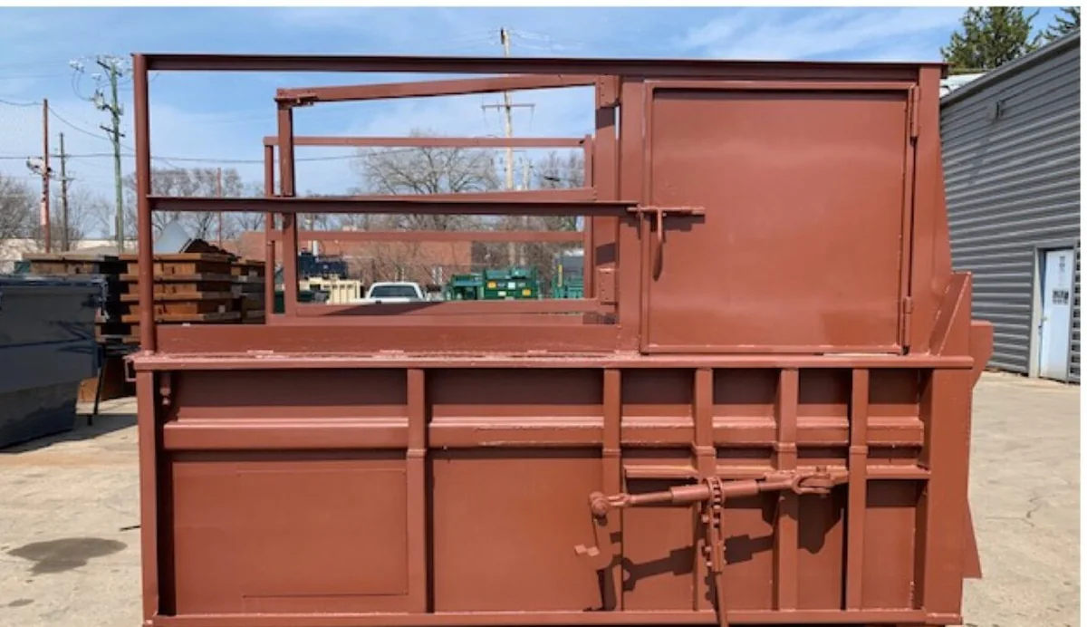 A used 2yd stationary compactor with walk-on deck and right side hopper